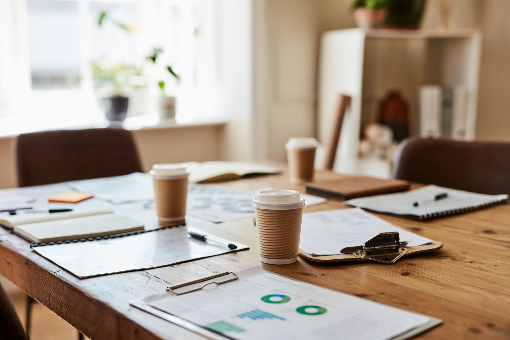 Meeting table with coffee and clipboard prepared for planning